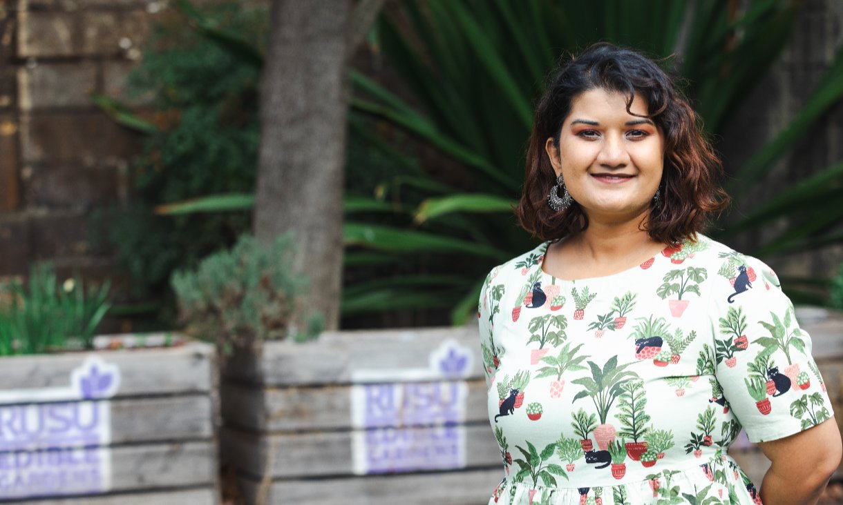 woman in dress standing in front of plant boxes
