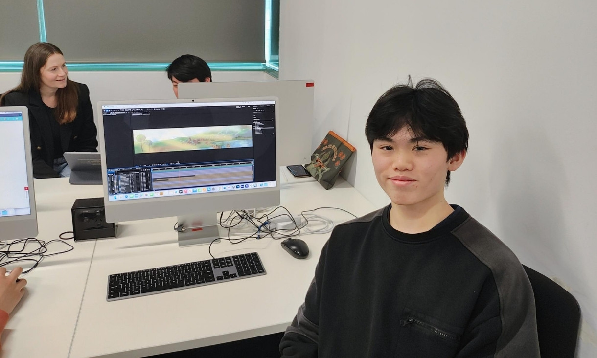 Alvin sitting with computer screen with design