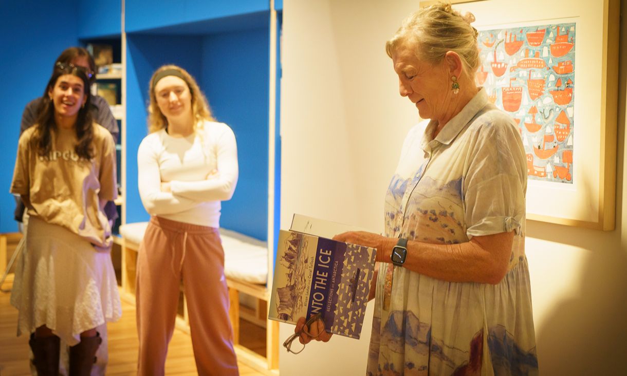 Alison Lester reading in front of illustration at gallery