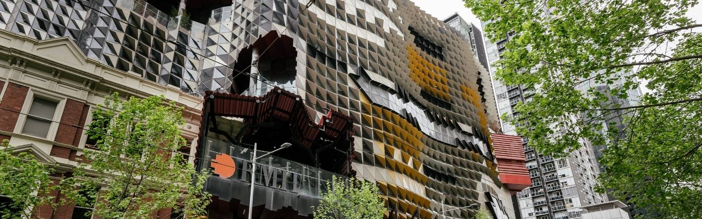 Exterior photo of RMIT building, with RMIT logo and trees framing the image.