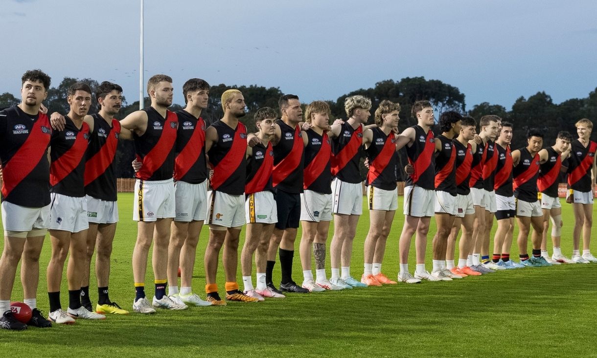 Essendon Football team lining up on grass