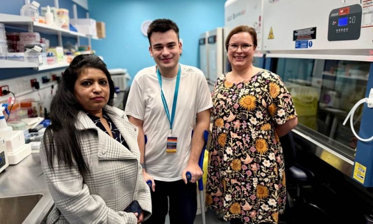 Three people standing in lab