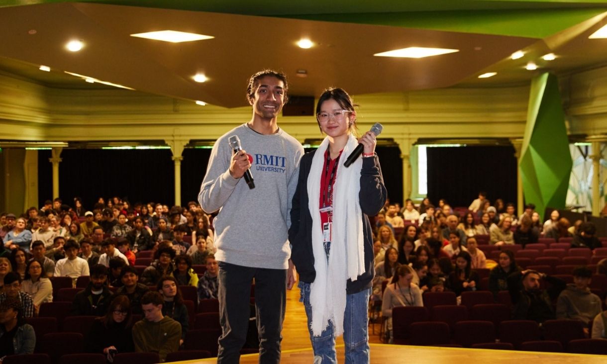 Two people holding microphones standing on stage