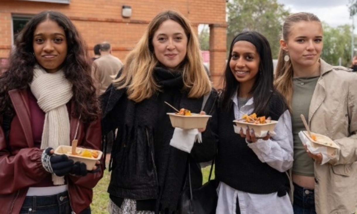 Four students eat food during RMIT O Week in 2025