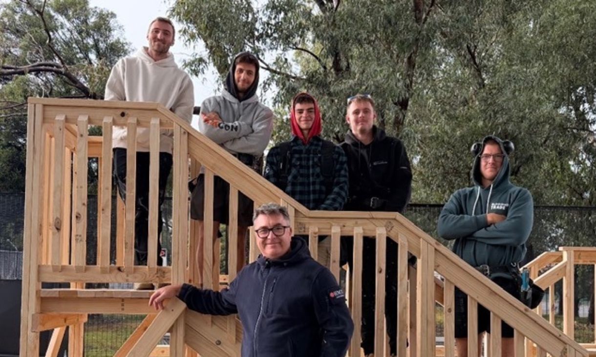 Six people standing on wood structure outdoors