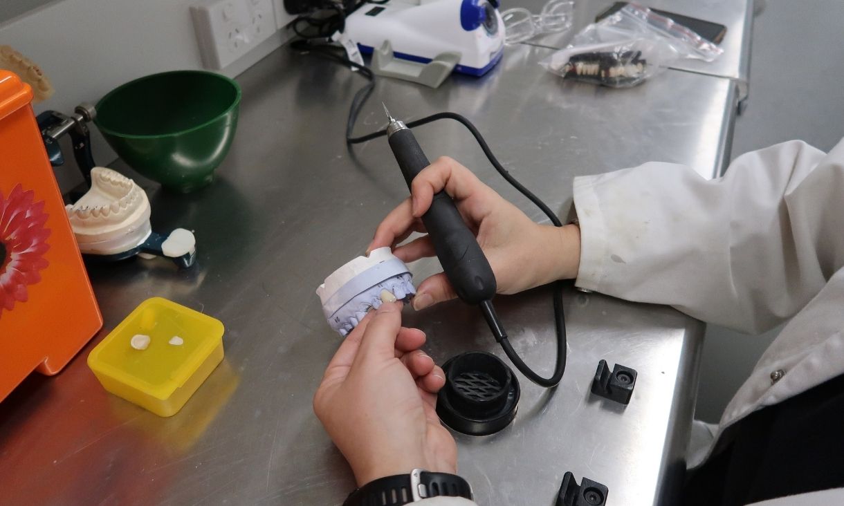 Person working on dental prosthetic in lab