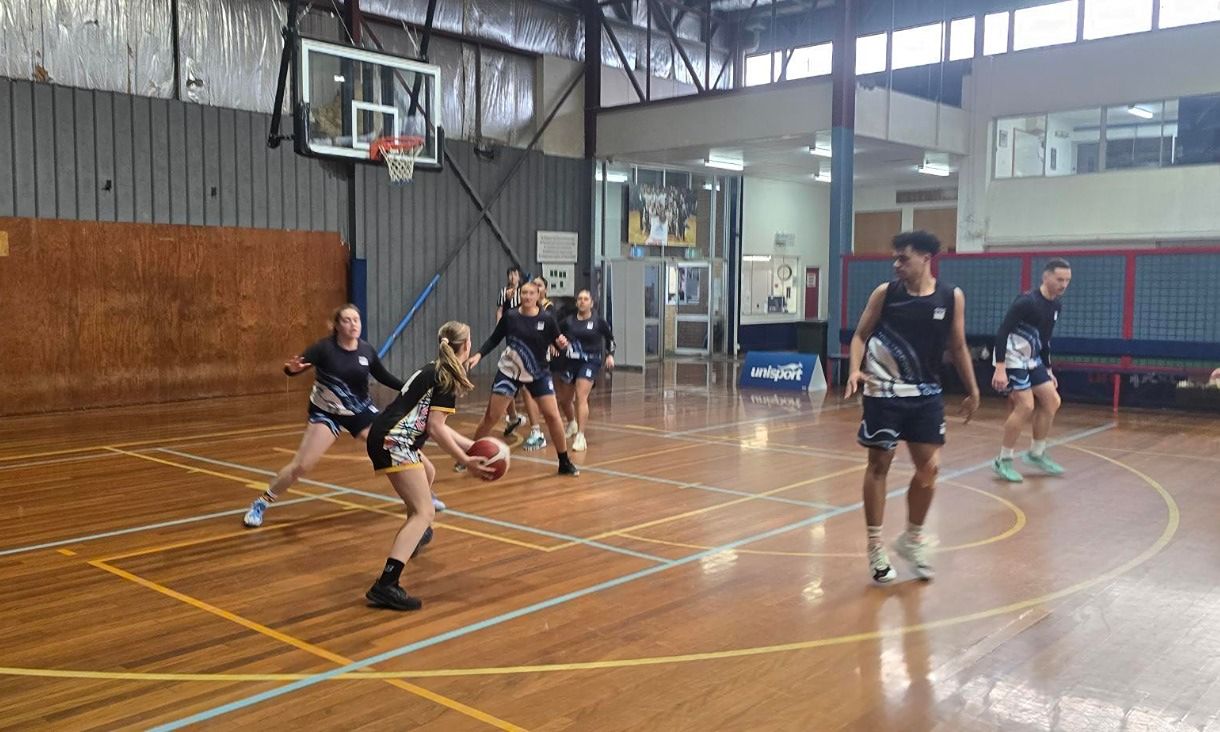 Students playing basketball indoors