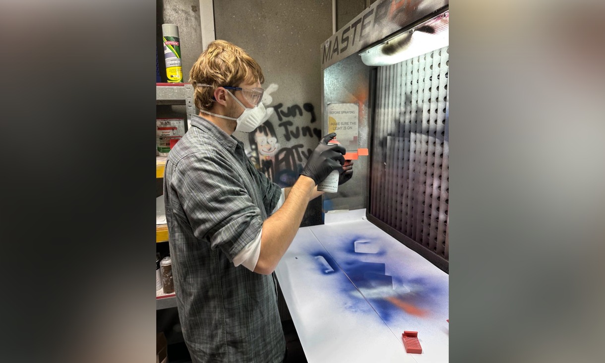 Man spray painting in booth 