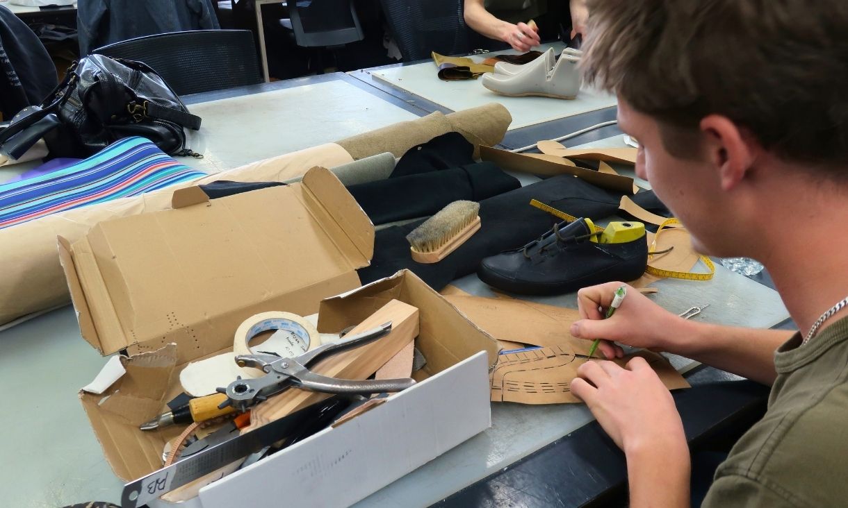 Student measuring leather and fabric