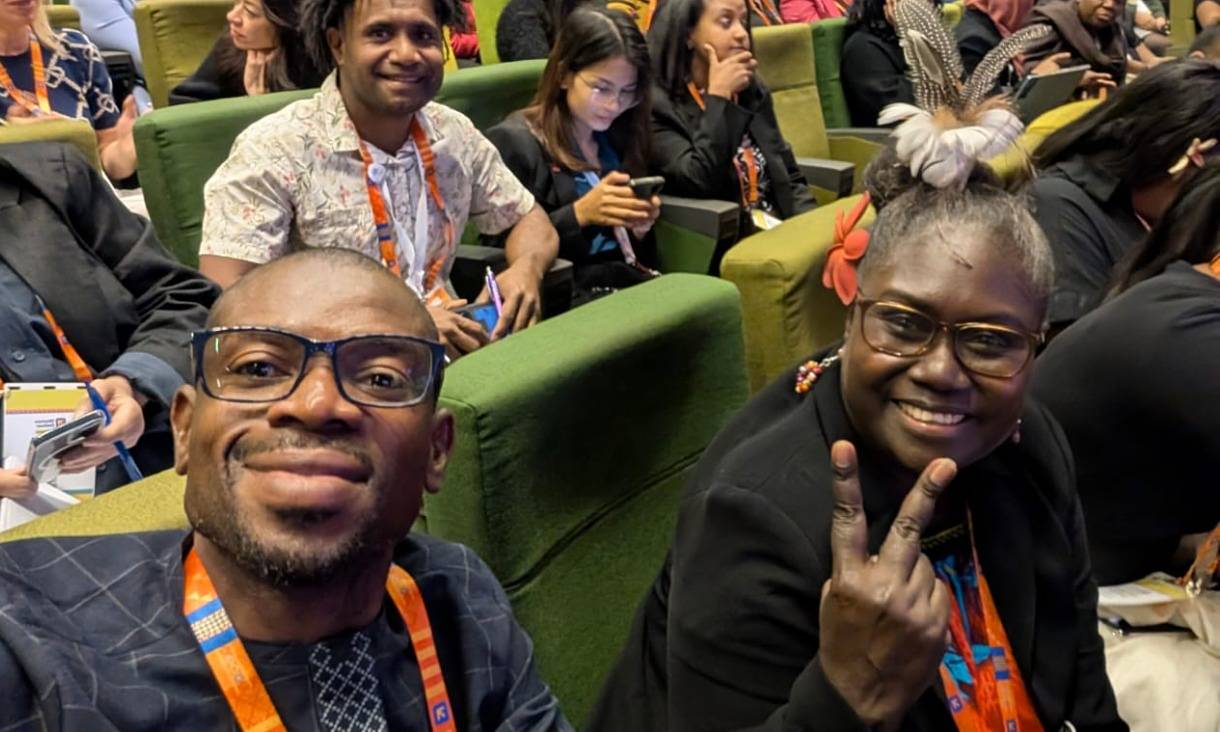 Two students in a lecture theatre posing for the camera.