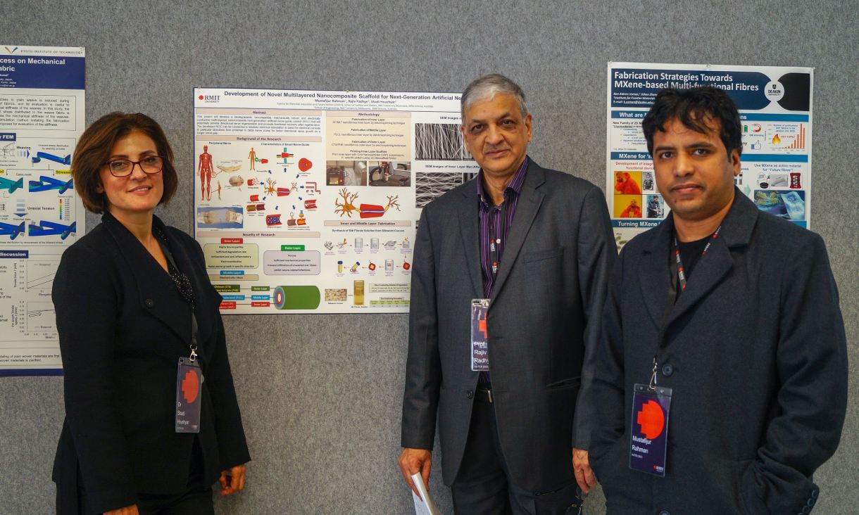 Dr Shadi Houshyar, Professor Rajiv Padhye and Mustafijur Rahman standing in front of their research poster on nanocomposite scaffolds for artificial nerves.