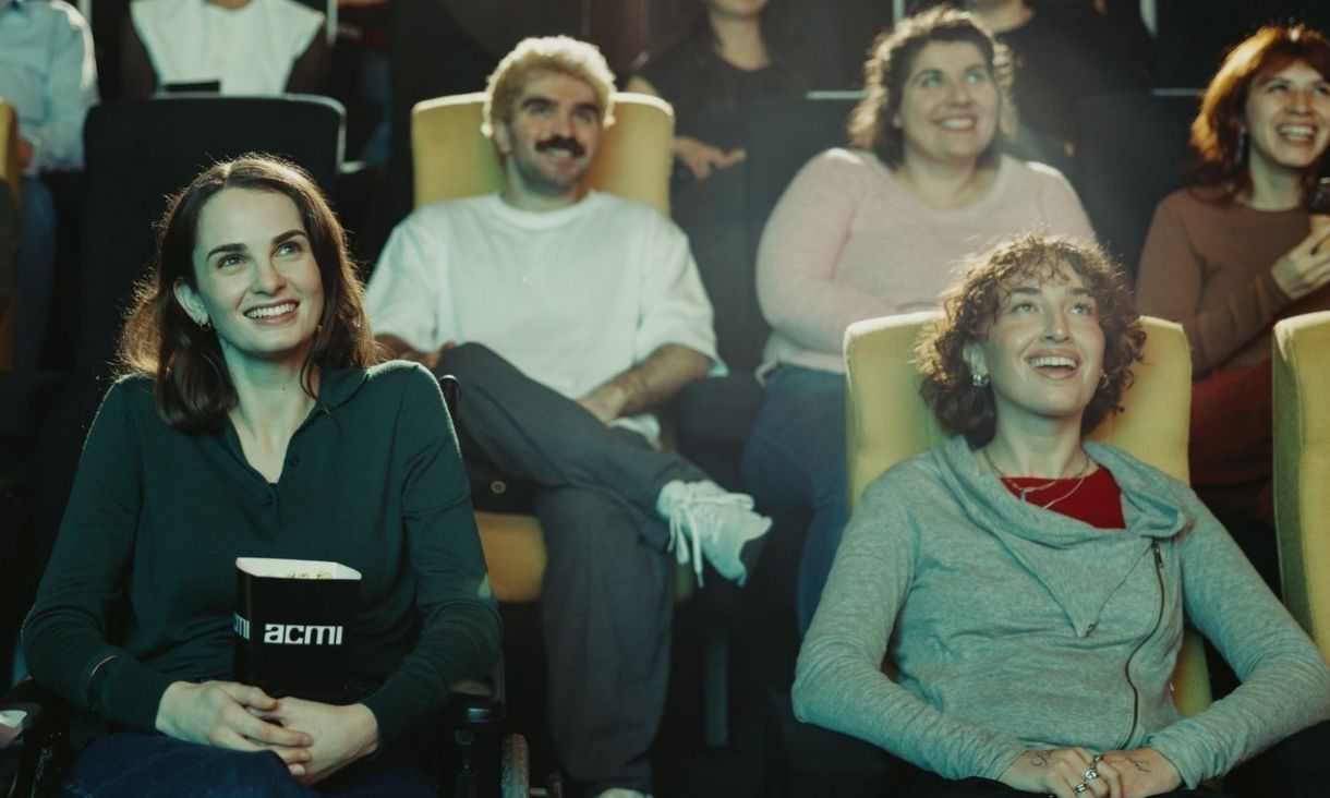 People smiling sitting in movie theatre