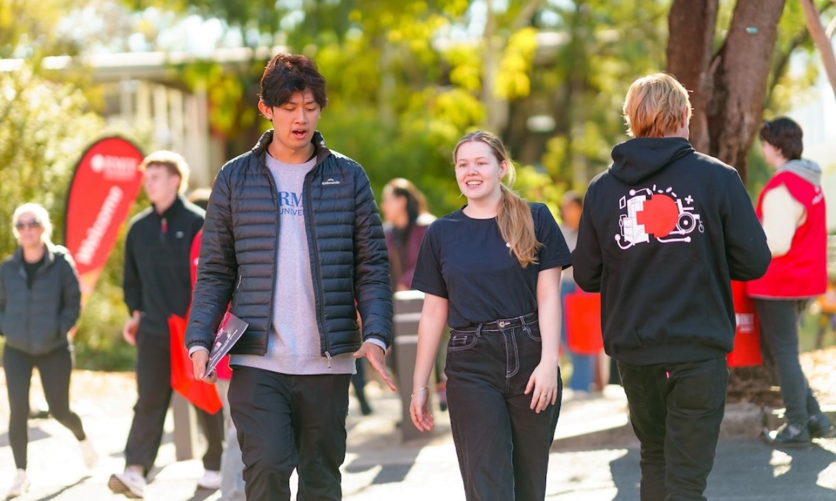 Students walking and chatting on a path at RMIT.