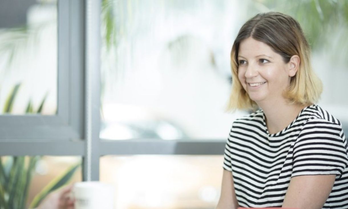 A woman talks to someone in a meeting.