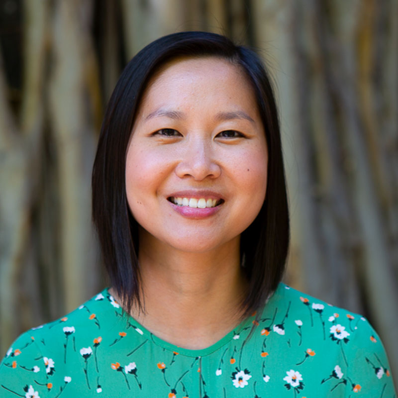 Headshot of Melissa smiling and wearing a green floral top.