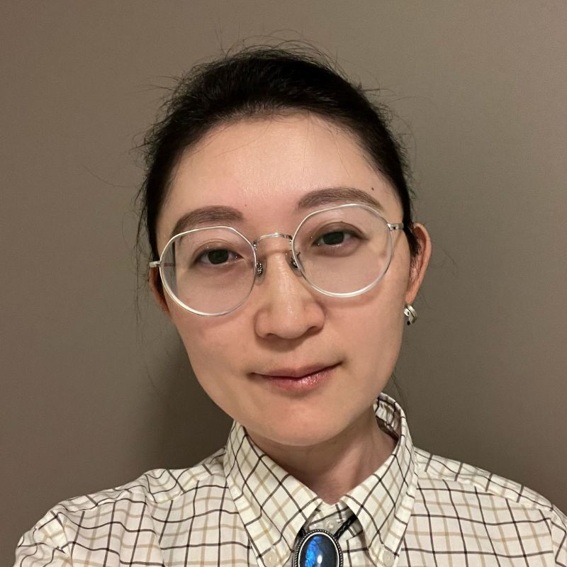 Sam wears glasses and smiles