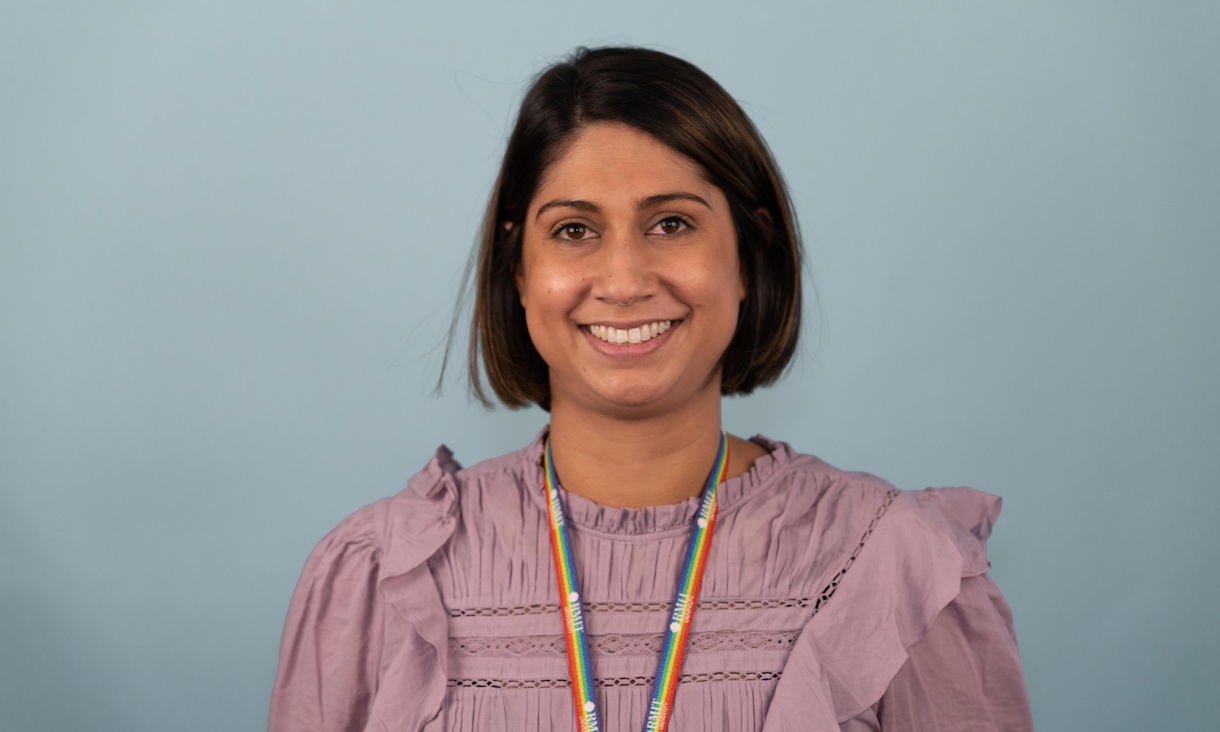 Emma wearing a pink blouse and rainbow lanyard.
