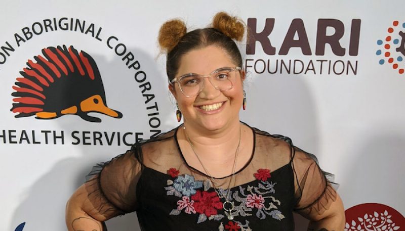 A student smiles at the camera at an awards ceremony.