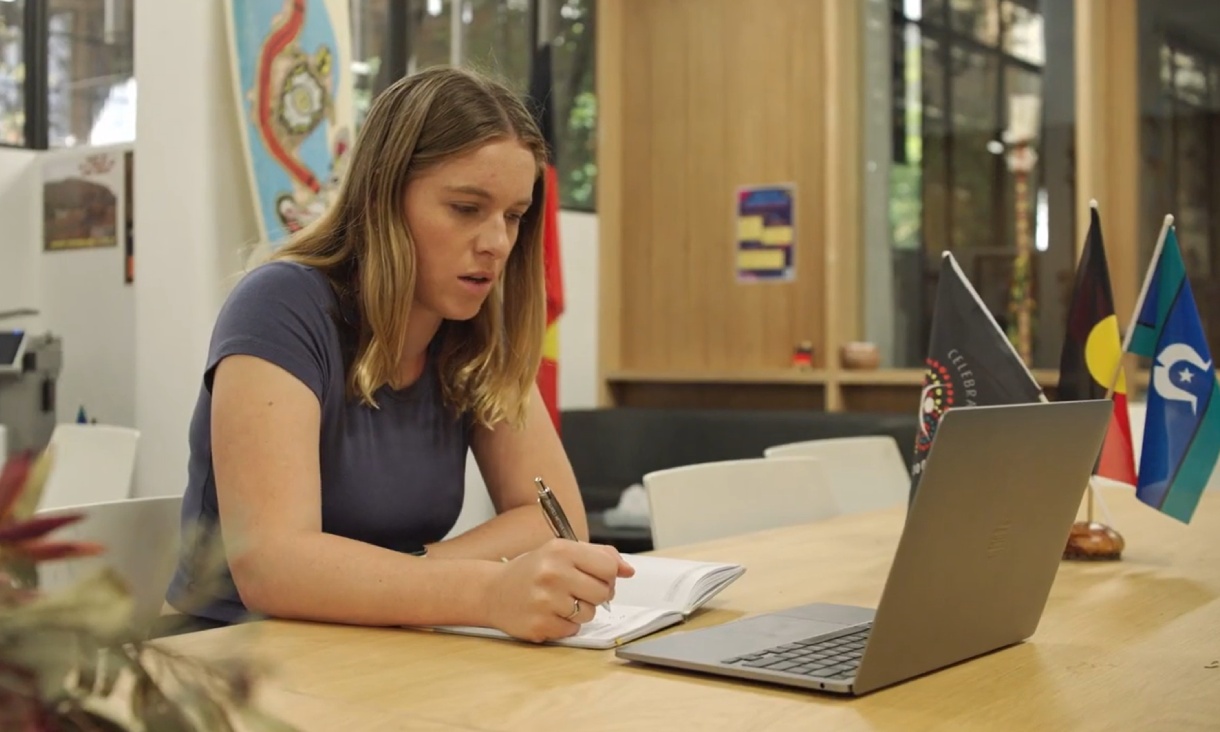 Person sitting at table with laptop