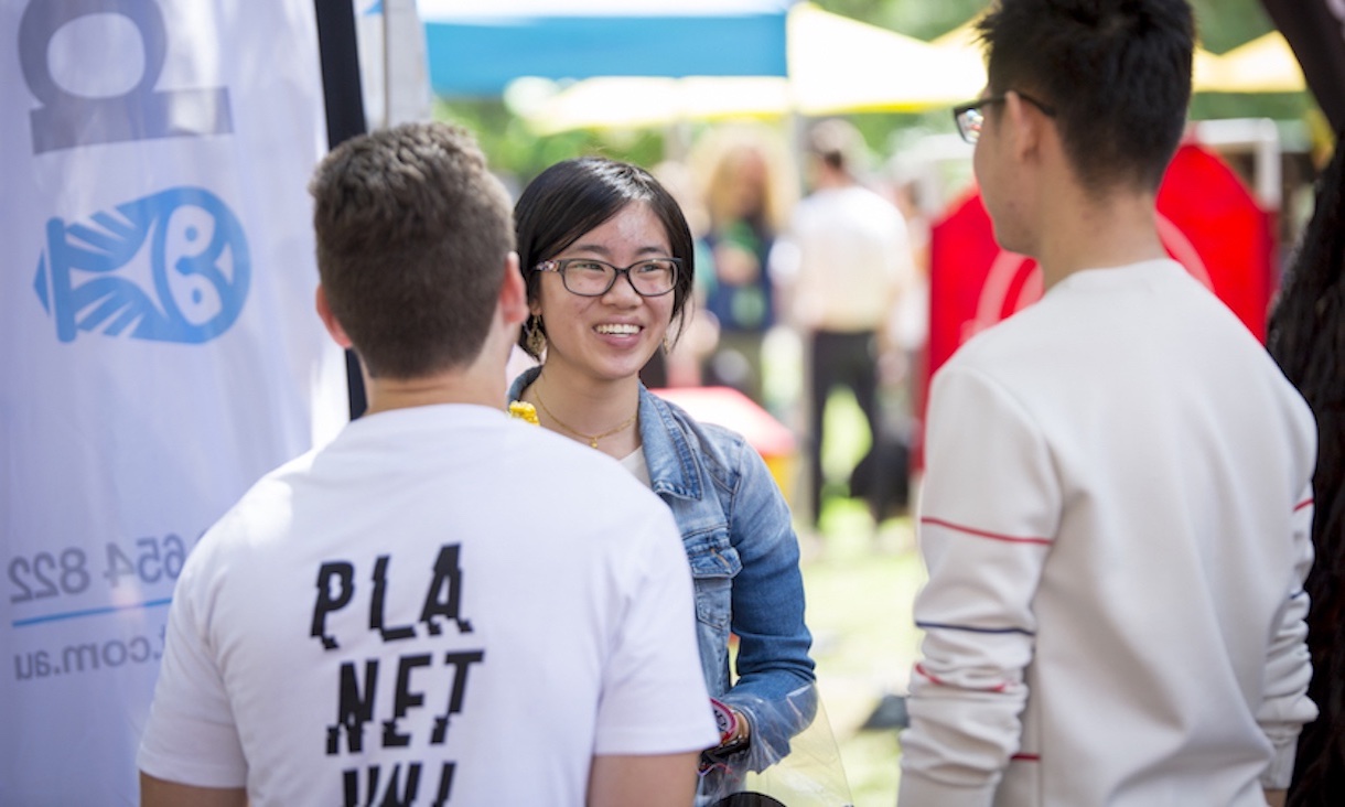 Students chat together outside at an event.