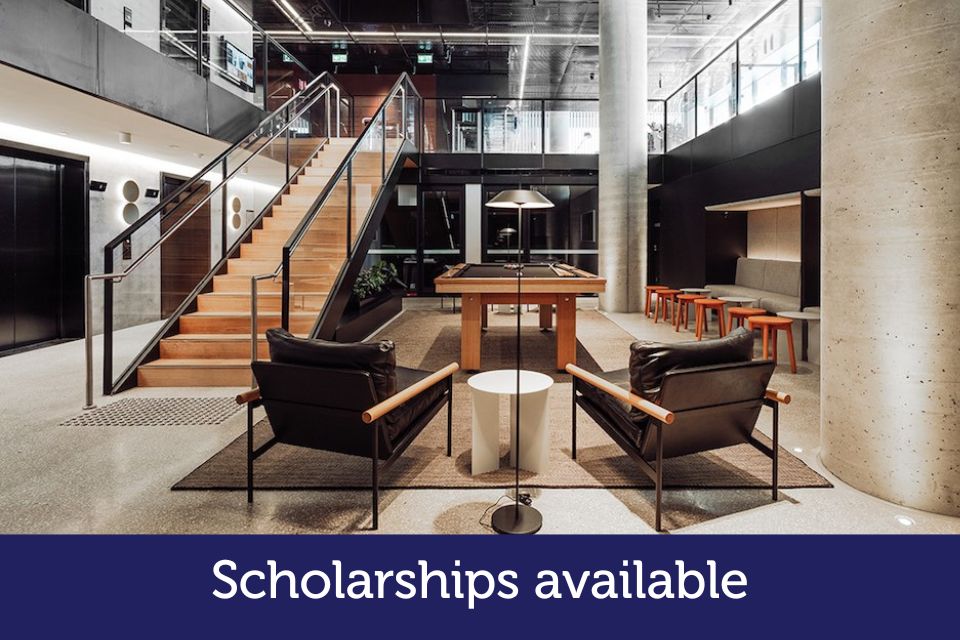 Two students walk through a lobby. The words 'Scholarships available' is printed on the photo.