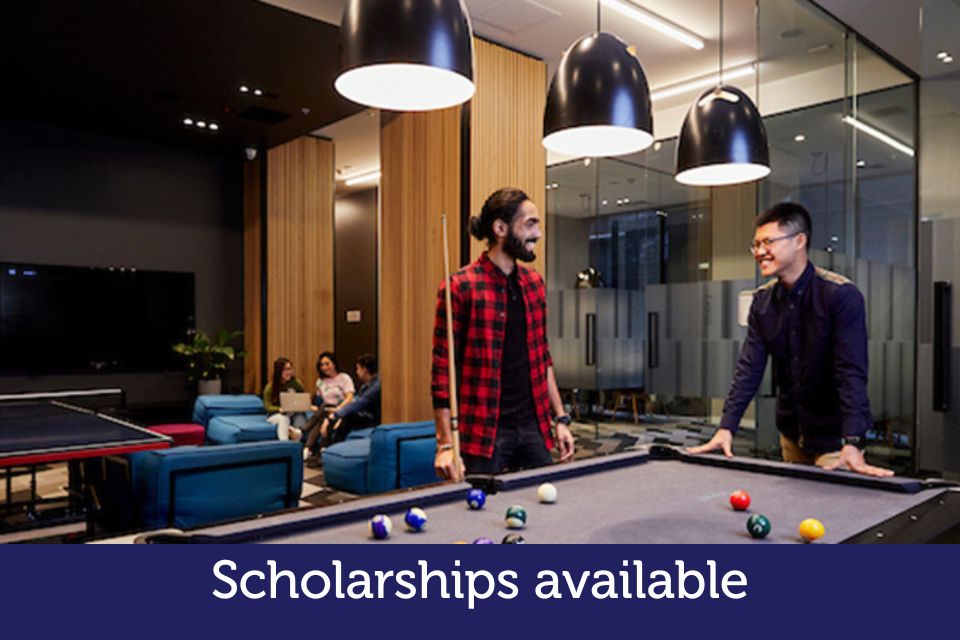 Smiling students play pool together.