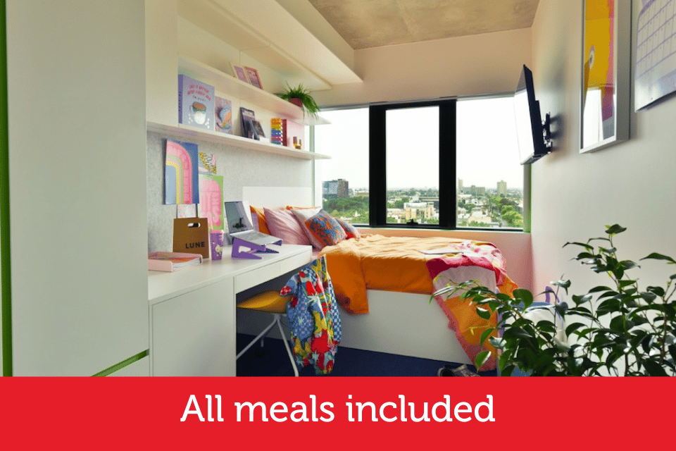 A female student studies on her bed in an apartment.