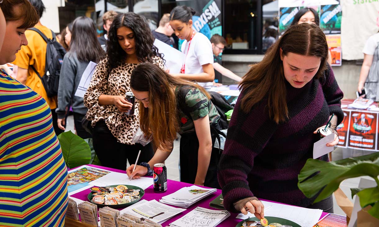 A person signing up at a stall. 