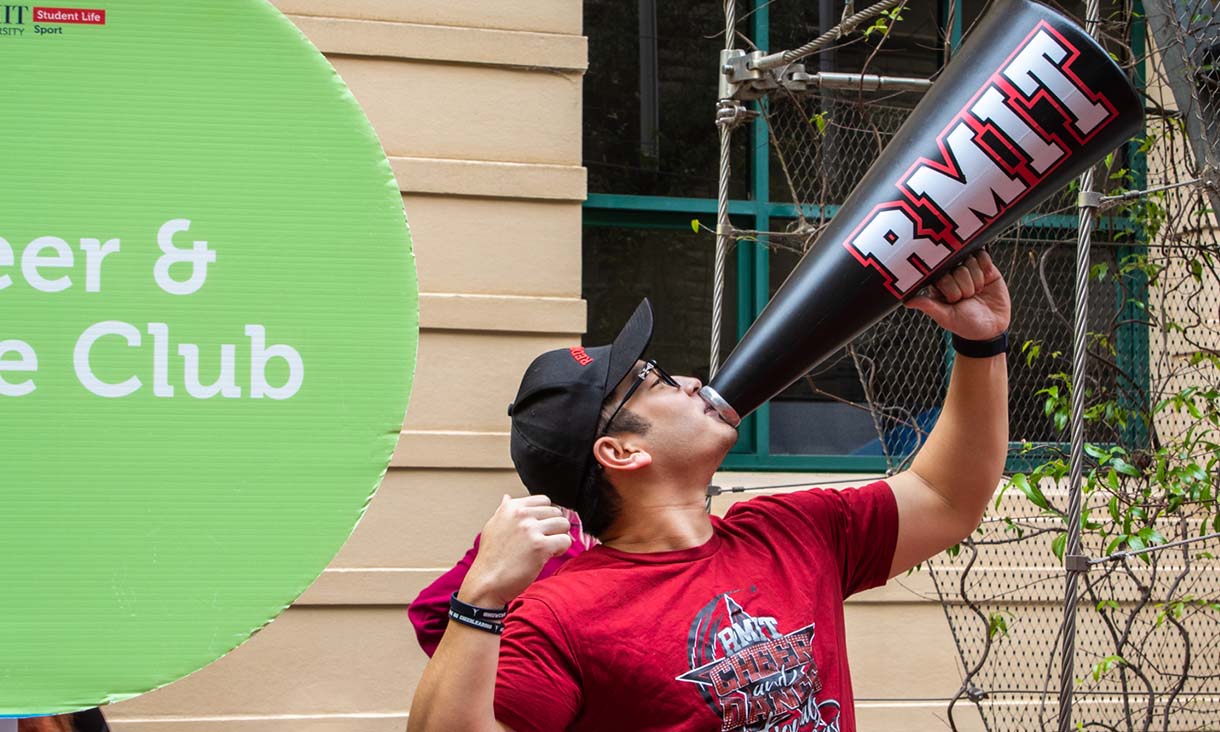 A cheerleader speaking through a megaphone