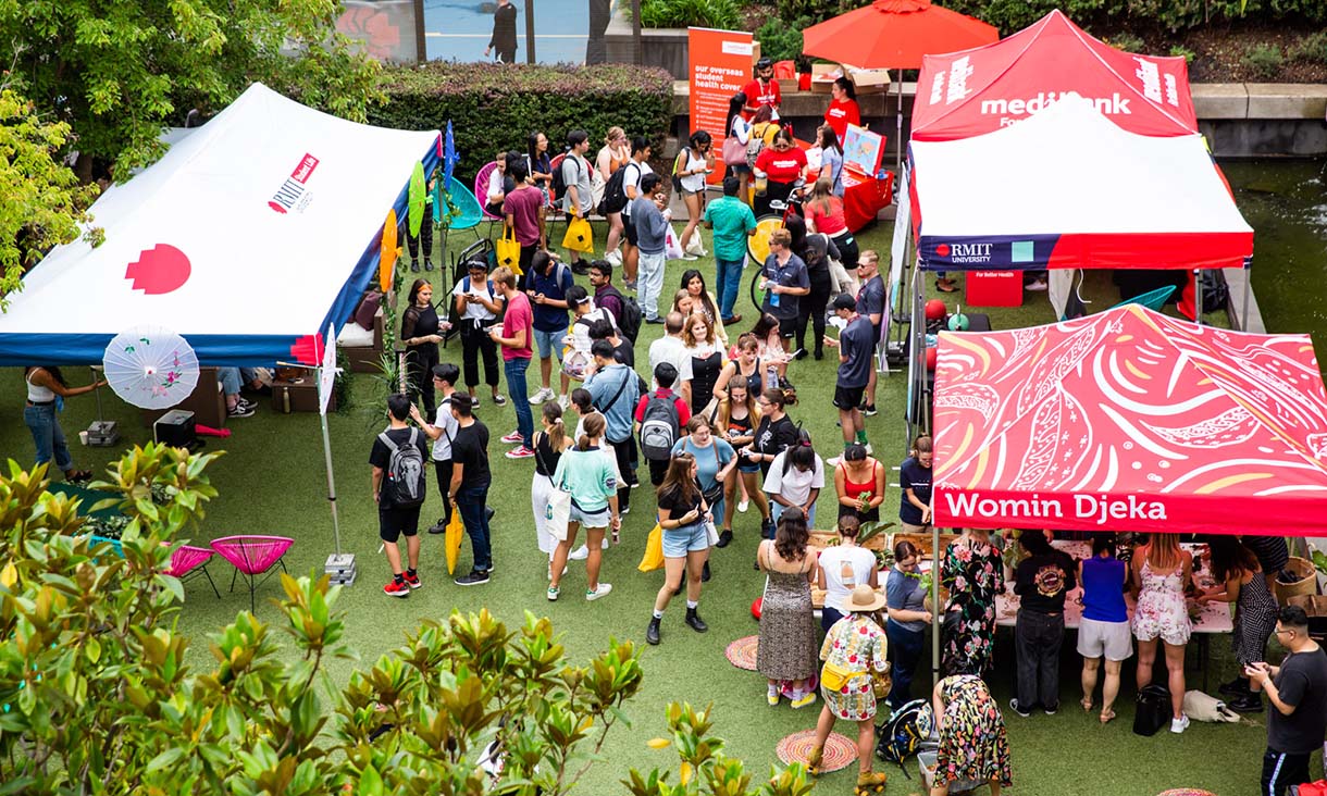 Overhead shot of people around event tents. 