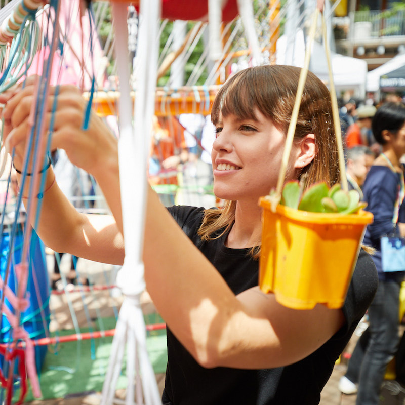 A student works on a large structure made of rope at the City Campus.