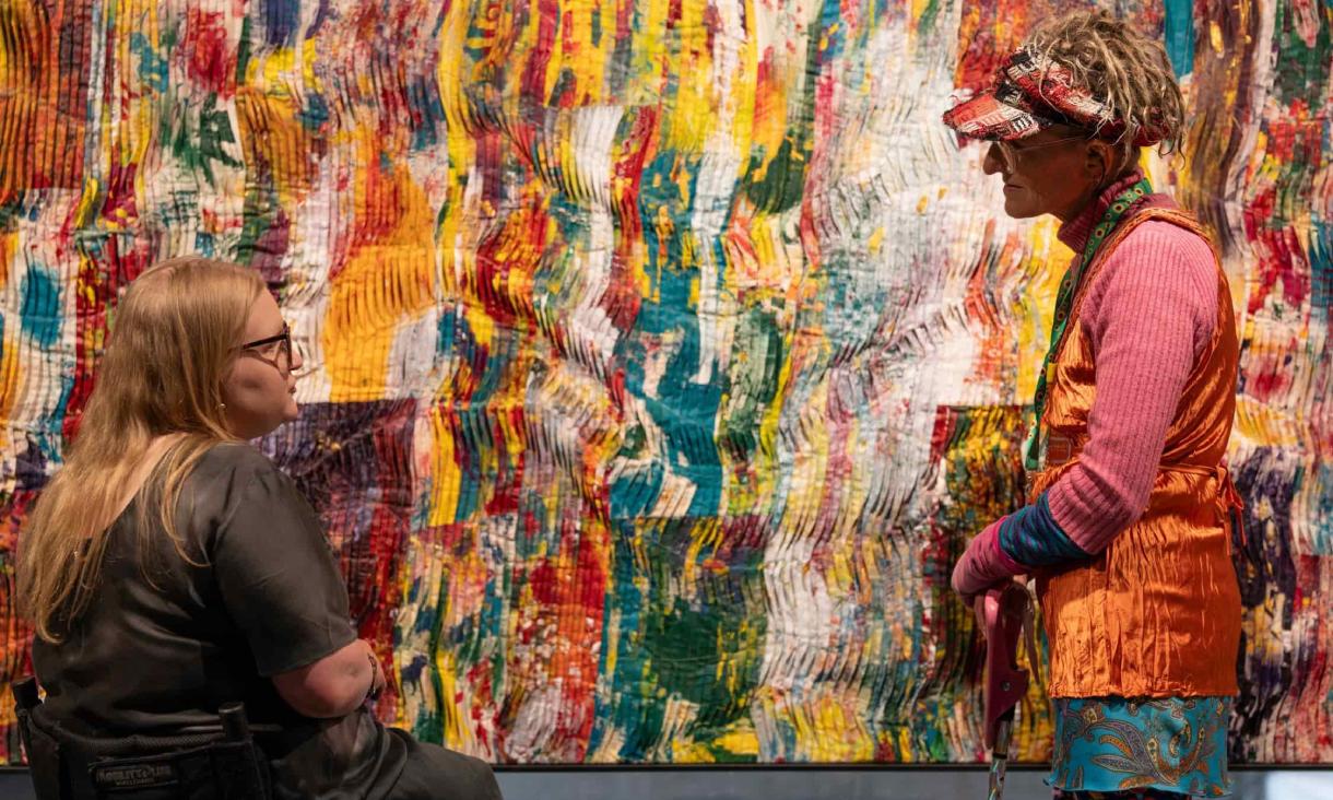 Colourful Mapiyal sculpture with greenery behind.