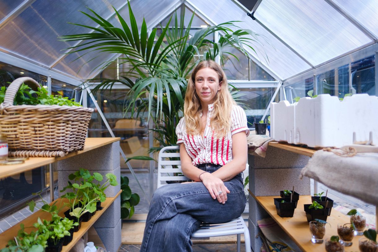 Person sitting inside greenhouse