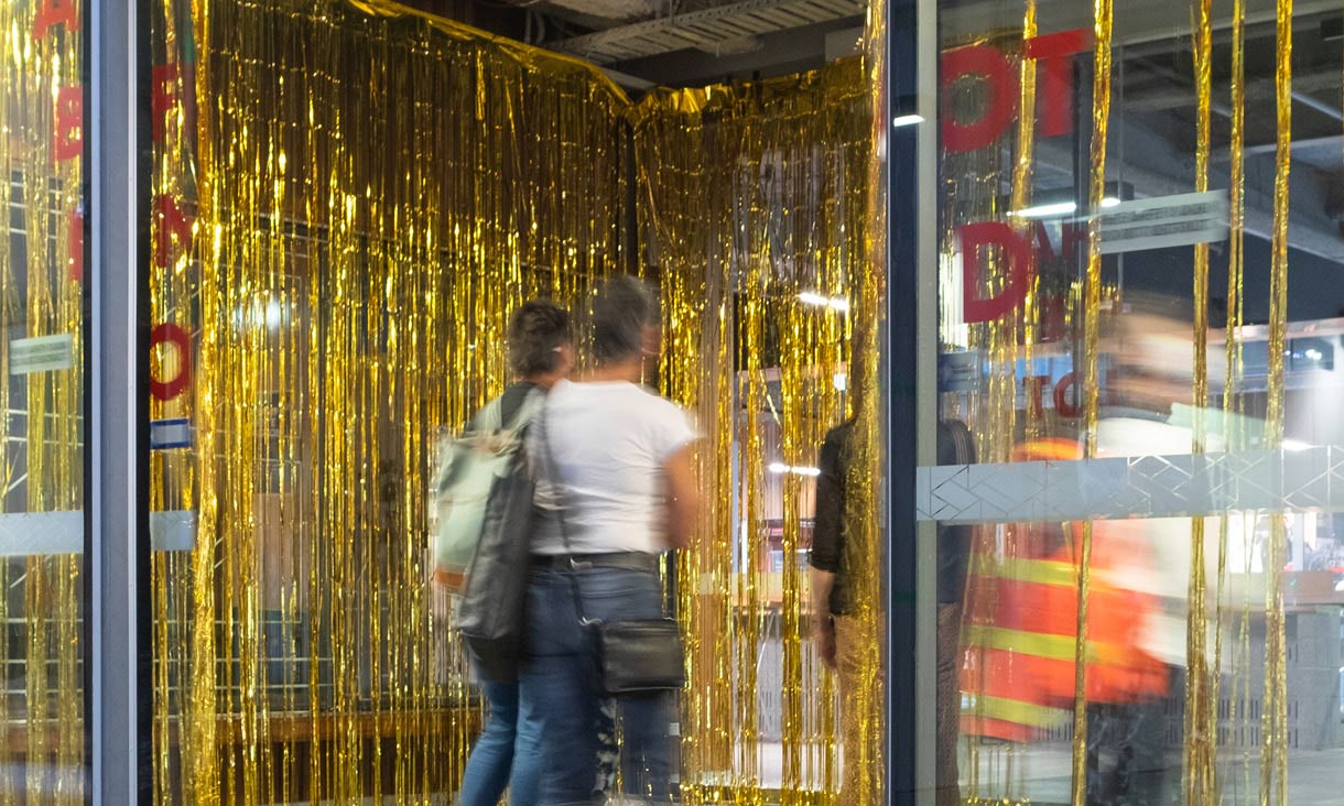 People walking through gold streamers