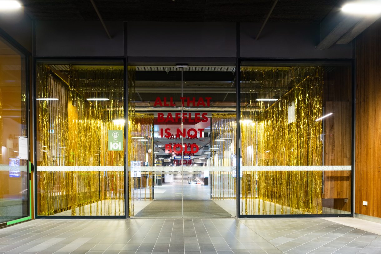 Sliding glass doors with gold streamers and red text
