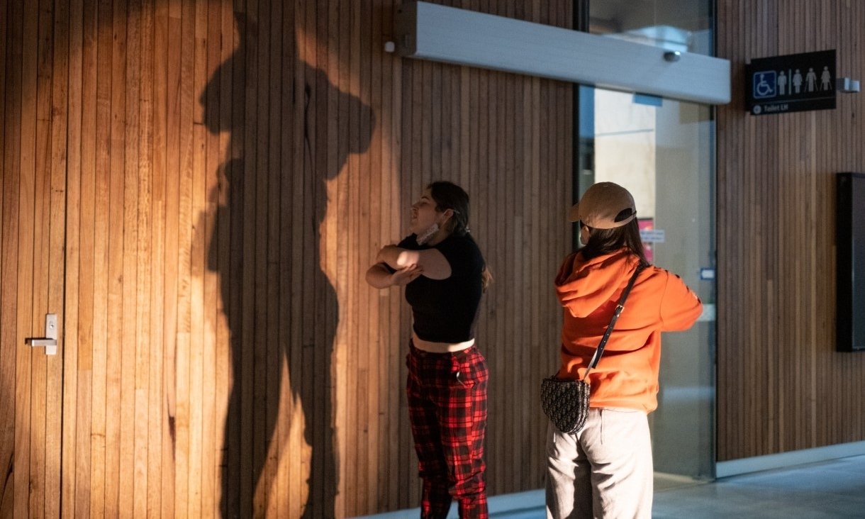 Two people taking photos of shadows