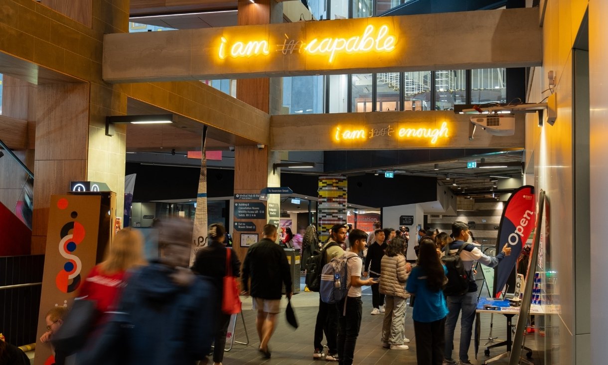 People standing around neon signs
