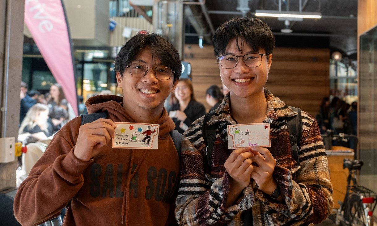 Two people holding up cards