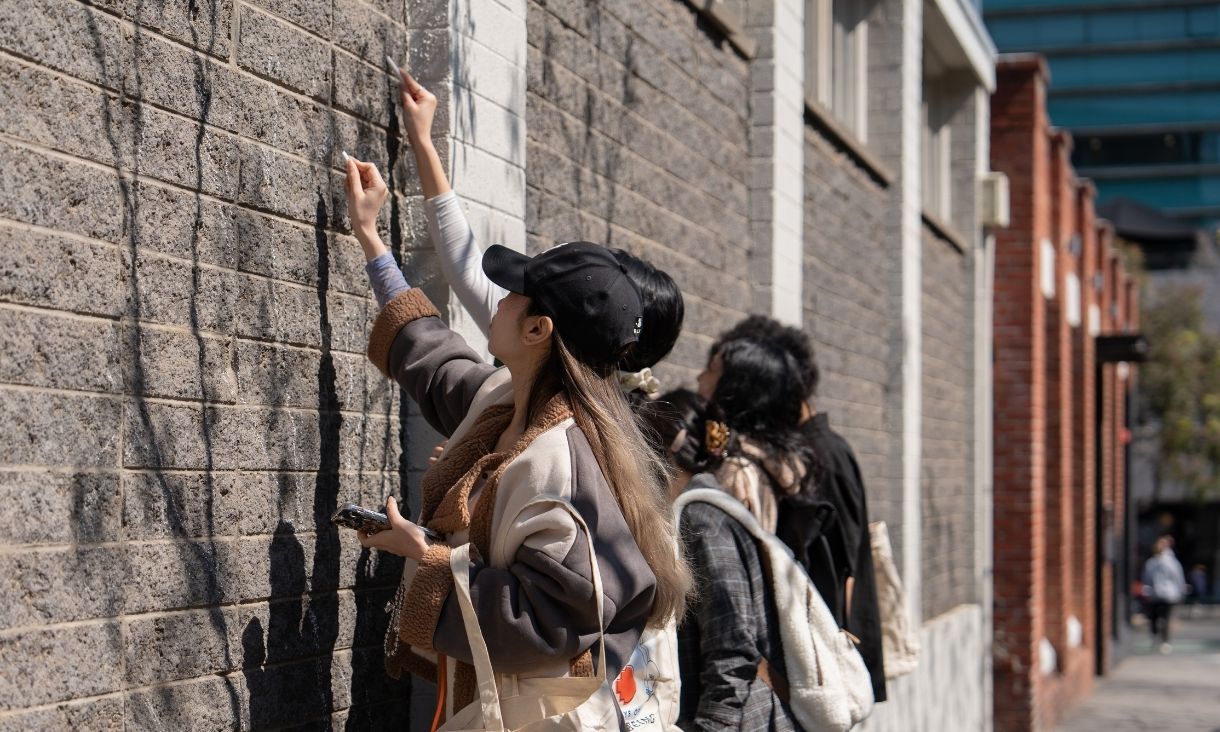 Person drawing on brick wall