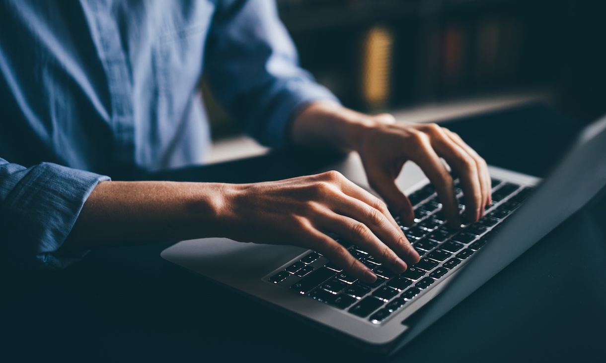 Close-up of hands typing on a laptop