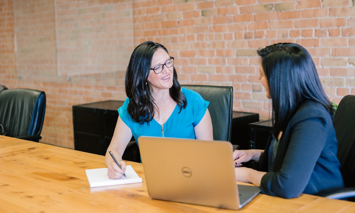 A mentor and an RMIT alumnus sit together with a laptop in discussion