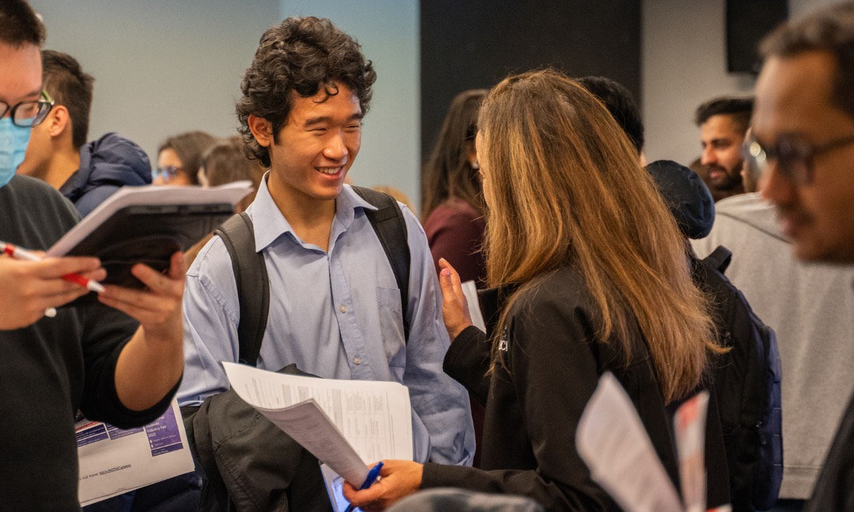 Student smiling at industry partner 