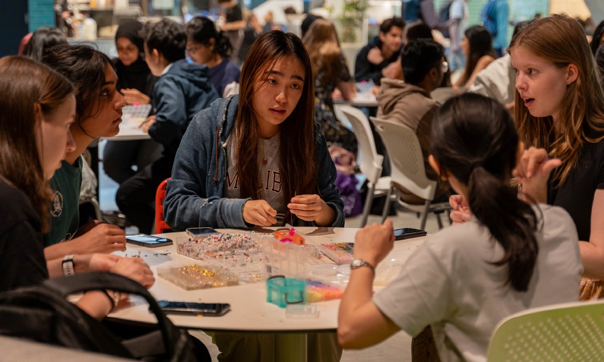 People beading at table