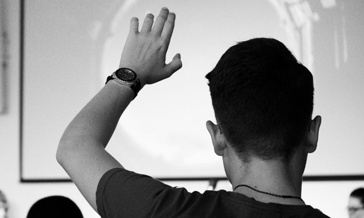 Student raising hand to ask a question