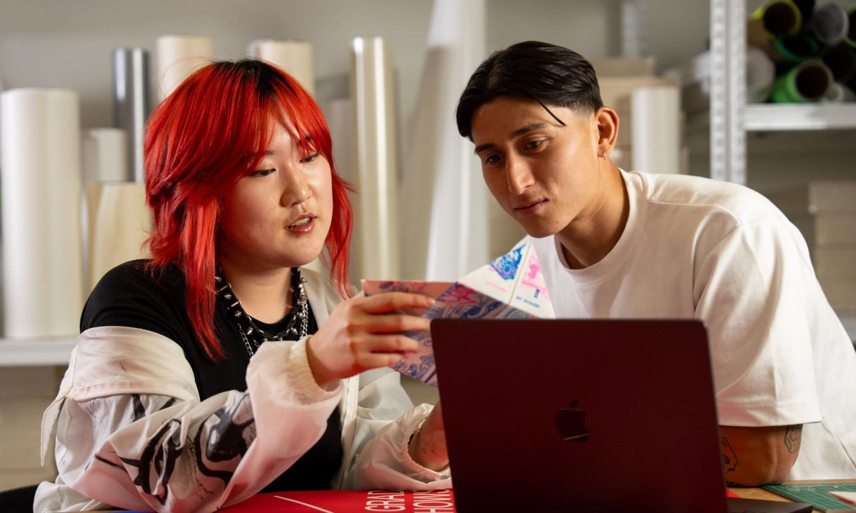 Two people talking over laptop