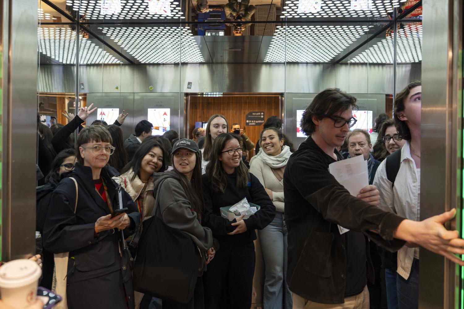 RMIT staff and students in Building 10 elevators where Artificial Intelligelism by Orlando Simmonds is displayed
