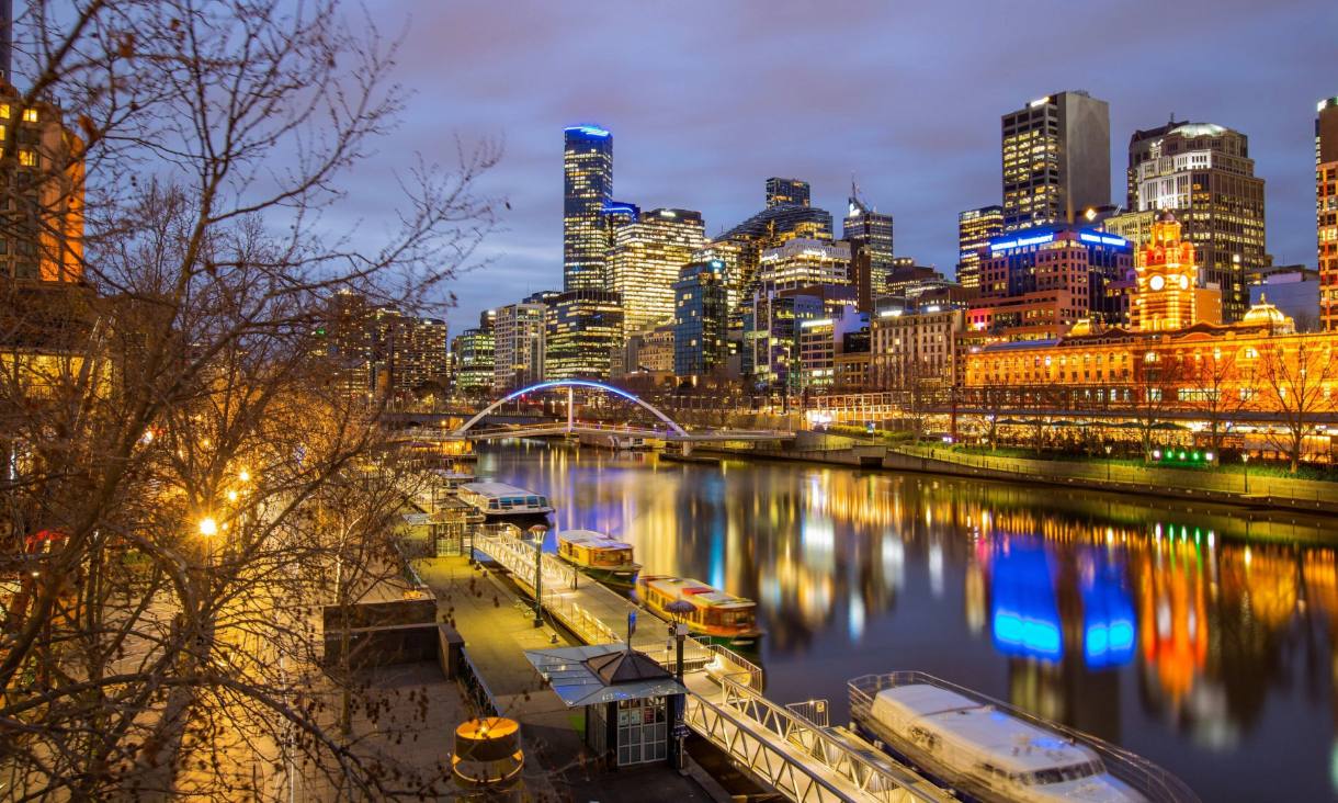 elbourne city skyline and the Yarra River lit up at dusk.