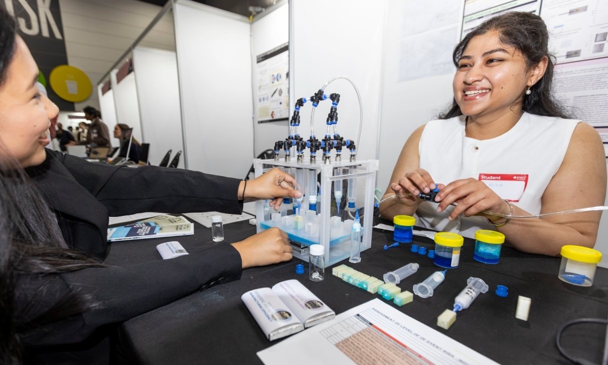 Two people sitting at table with scientific equipment