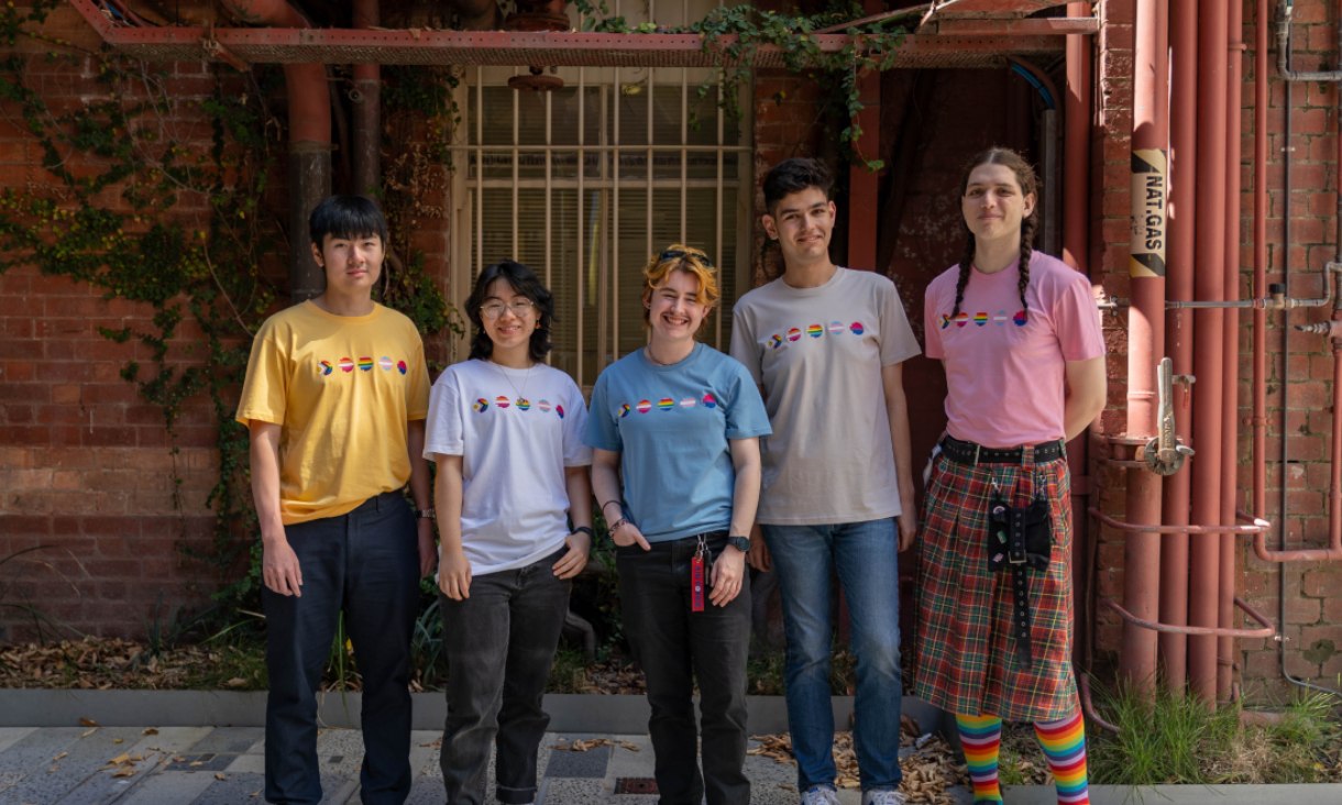 Group of poeple wearing the RMIT Pride Tee in yellow, white, blue, bone and pink.