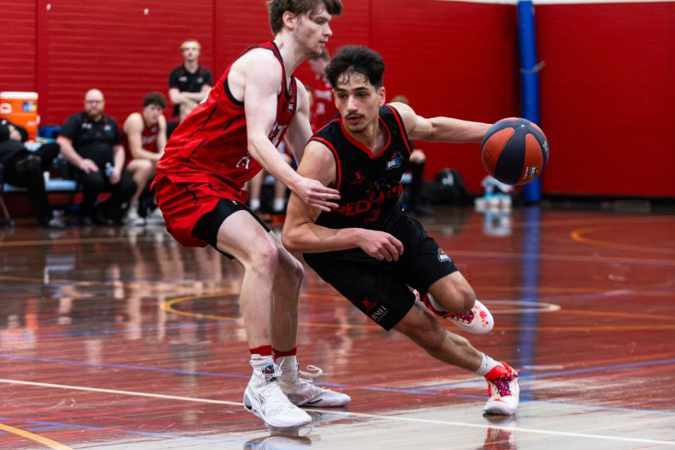 Two basketball players competing on the court.